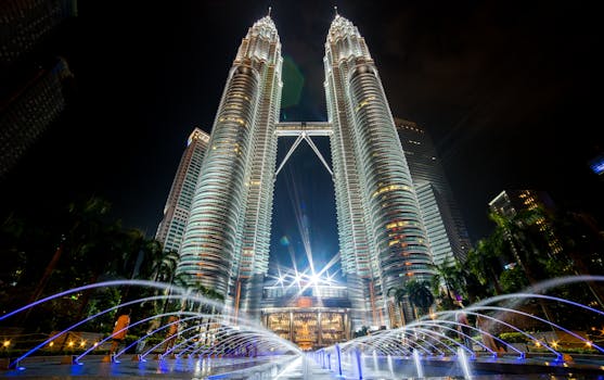 Stunning night view of the illuminated Petronas Twin Towers in Kuala Lumpur with fountains in the foreground.